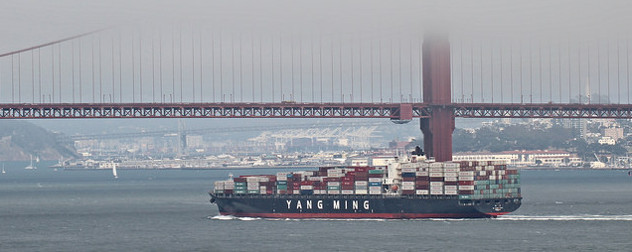 cargo ship passing by the Golden Gate Bridge on a foggy day