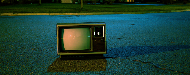 vintage TV sitting in a street at night