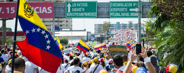 protesters with flags and signs march on the Palace of Justice in Maracaibo, Venezuela