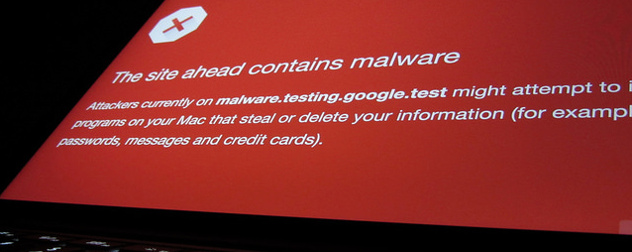 laptop screen displaying malware warning on red background