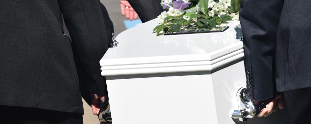 detail of pallbearers carrying a white coffin with flowers