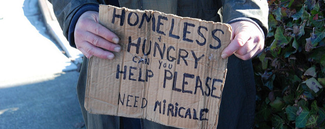 cardboard sign that reads 'Homeless & Hungry Can You Help Please Need Miracle'