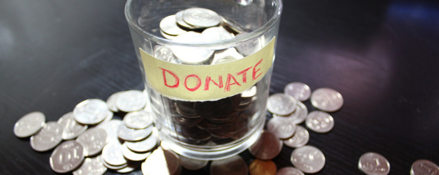 glass with tape labeled Donate, full of coins