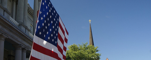 American flag in foreground, steeple in the back