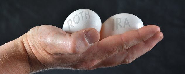 hand holding two eggs with the words 'Roth' and 'IRA' against a black background