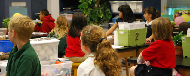 children sitting in a classroom, facing away from the camera