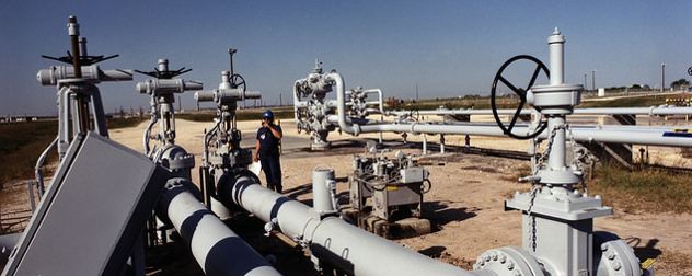 worker standing among wellhead and valves at Bryan Mound, an SPR storage site