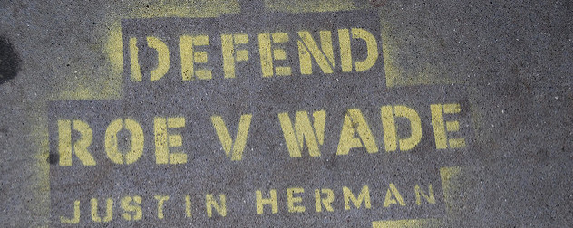 spray-painted sign that reads 'Defend Roe v. Wade'