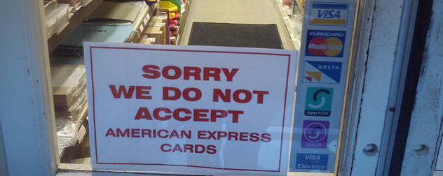 sign in a shop window that reads 'Sorry We Do Not Accept American Express Cards'