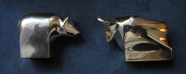 brass bear and bull paperweights against a navy blue velvet background