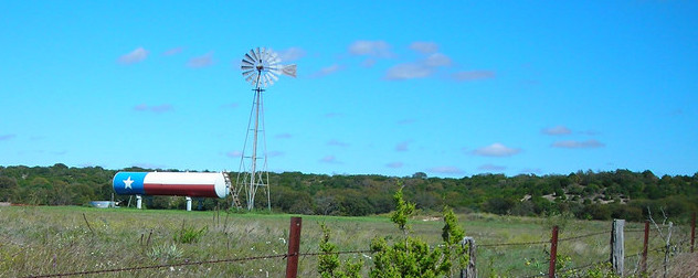 water tank painted to resemble the Texas flag in a field, next to a windpump