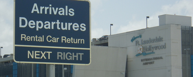 Arrivals-Departures sign in foreground with Ft. Lauderdale Hollywood International Airport facade in background