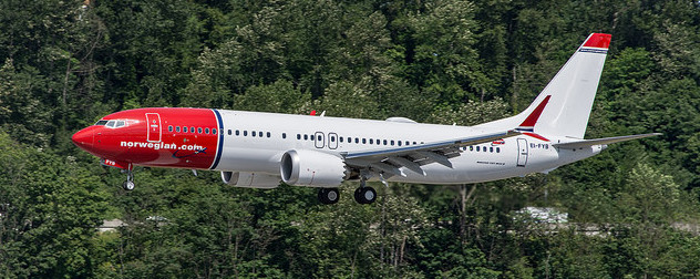 Norwegian Air Shuttle Boeing 737 MAX 8 in flight against trees