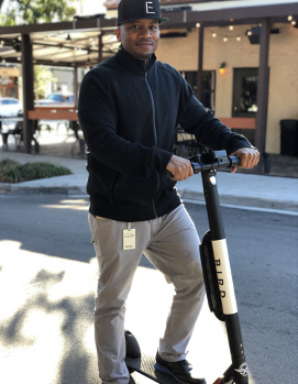 Shomari Hearn posing with Bird electric scooter.