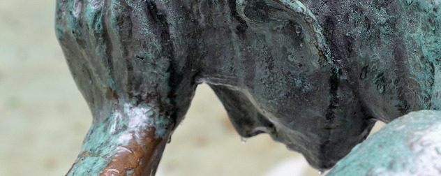 detail of statute of person leaning on hand as if in despair or in thought