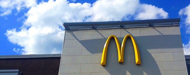 McDonald's facade with logo against a blue sky.