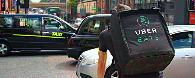 Uber Eats delivery person on a bike, from behind.