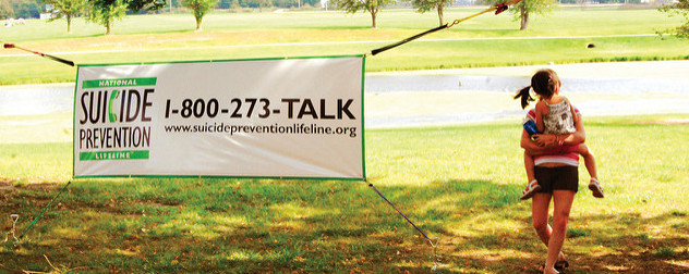 outdoor banner advertising the National Suicide Prevention Lifeline with a telephone number and a URL.