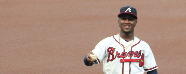 Ozzie Albies in uniform for the Atlanta Braves, holding a baseball.