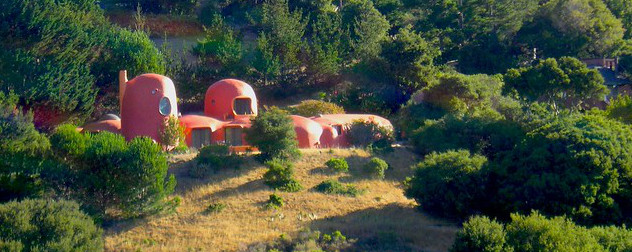 the Flintstone House in an all-orange paint job, seen from a distance.