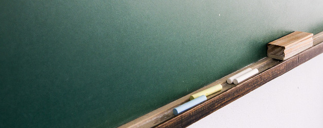 detail of blank blackboard with eraser and chalk.