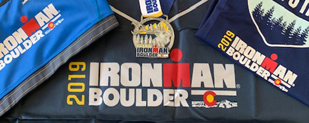 Ironman Boulder 2019 swag, including a shirt, medal, and bag.