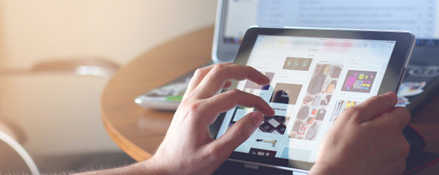 hand interacting with an iPad tablet displaying a social feed driven by algorithms.