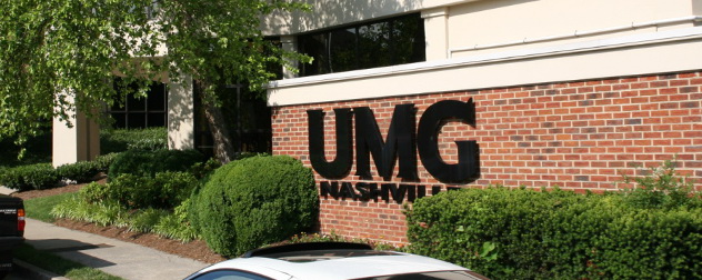 Universal Music Group (UMG) logo on a brick wall.