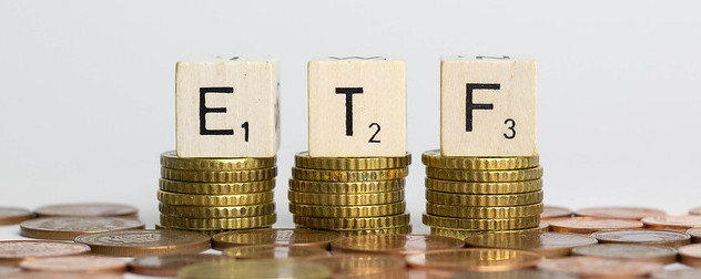 ETF letter blocks on piles of coins.