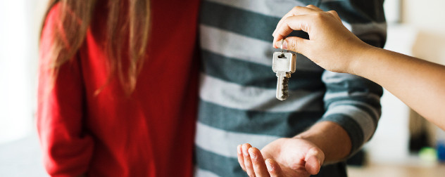 person handing keys to a couple (detail).