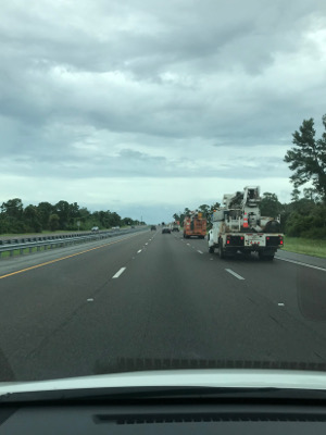 utility trucks on the highway under an overcast sky.