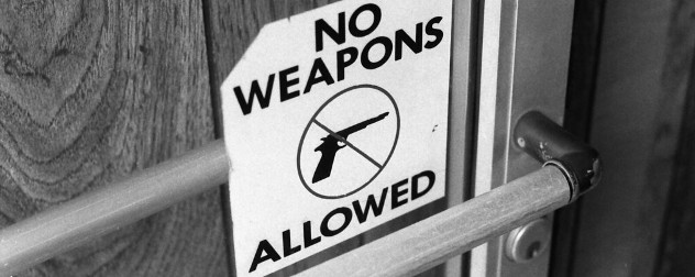 No Weapons Allowed sign on door, with no symbol over an image of a gun.