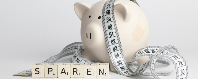 Sparen, or 'to save' in Germany, spelled out in blocks next to a piggy bank and a tape measure.