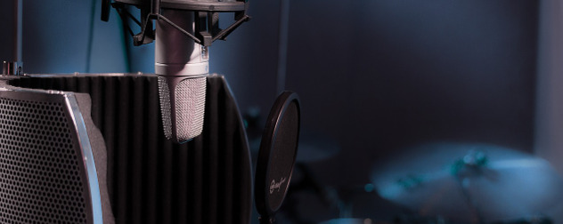 detail of microphone in recording studio with cymbals in background.