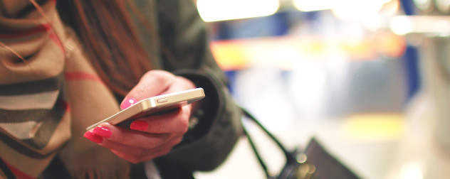 person with painted nails reading text messages on an iPhone.