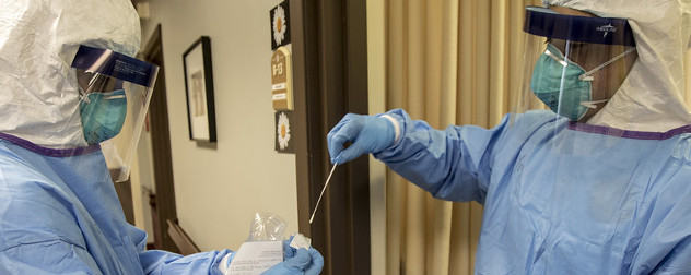 A medic with the Massachusetts National Guard administers COVID-19 tests at a nursing care facility,