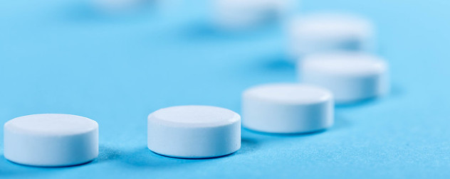 round white pills against a blue background.