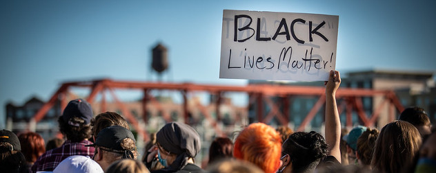 protesters, including one holding a sign that says 'Black Lives Matter,' at a protest following the death of George Floyd.