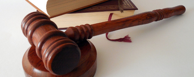 wooden gavel in front of books.