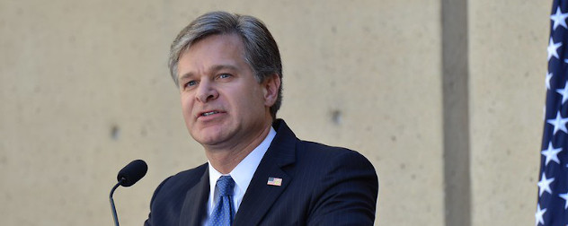 FBI Director Christopher Wray, speaking at a podium.