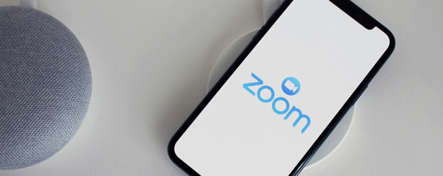 Google Home assistant and smartphone displaying a logo for the Zoom app.