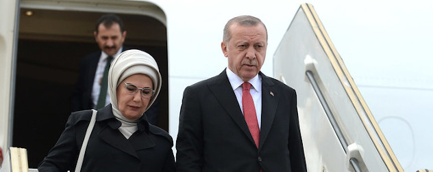 President of Turkey, Recep Tayyip Erdogan, descending stairs to exit an airplane.