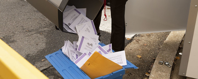 absentee ballots being poured into a bin ahead of Election Day.