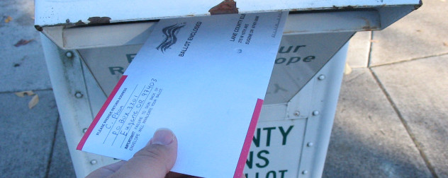 Voter putting a sealed ballot into a ballot return box, Lane County, Oregon.