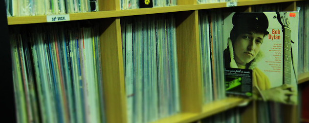 Bob Dylan album pulled out of a line of vinyl records in a shop.