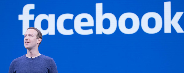 Facebook founder Mark Zuckerberg speaking in front of a blue slide with Facebook's name.