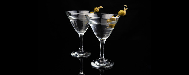 two martinis against a black background.