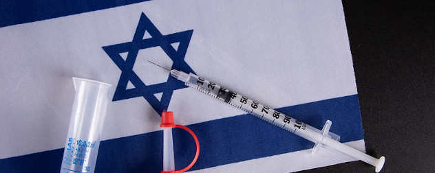 syringe and other vaccine supplies against a backdrop of Israel's flag.