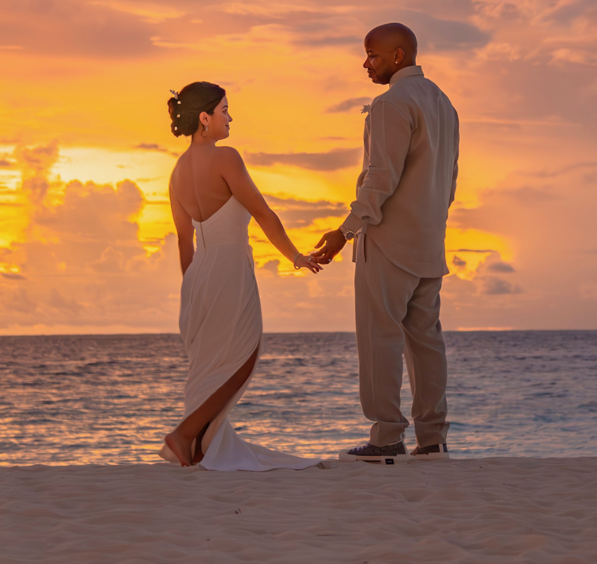 Kirstie Ward and Shomari Hearn on a beach in wedding apparel.