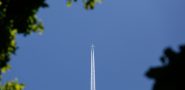Plane flying upward in blue sky.